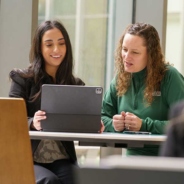 two women students looking at a tablet
