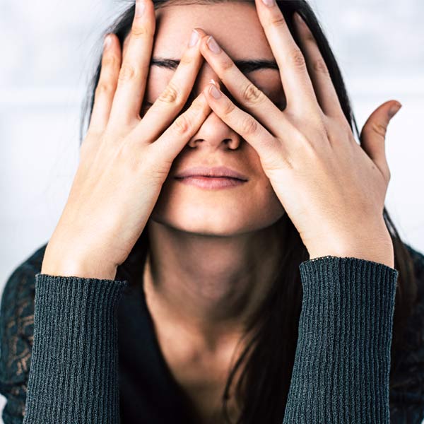 Woman covering her eyes with her hands