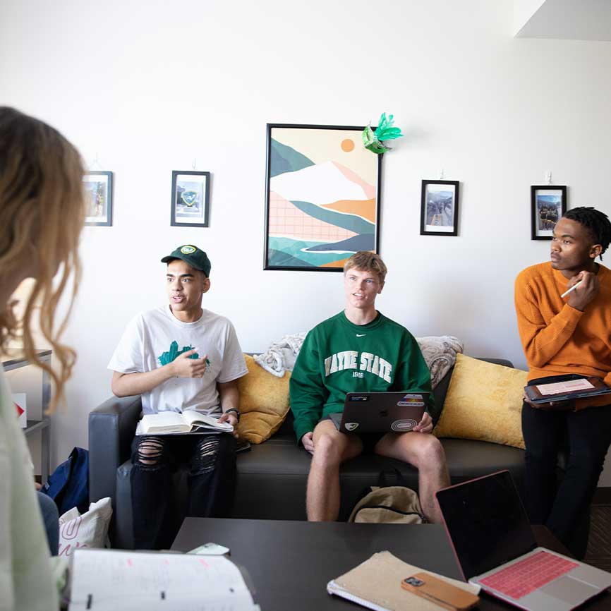 Students sit together in a room studying and talking